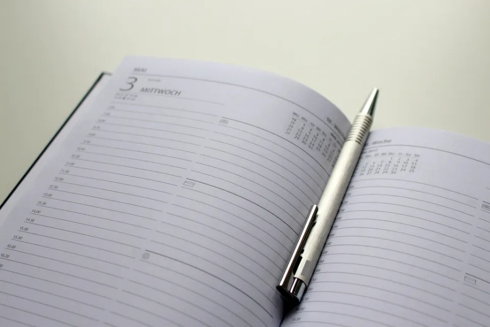 Agenda aberta com caneta sobre a mesa