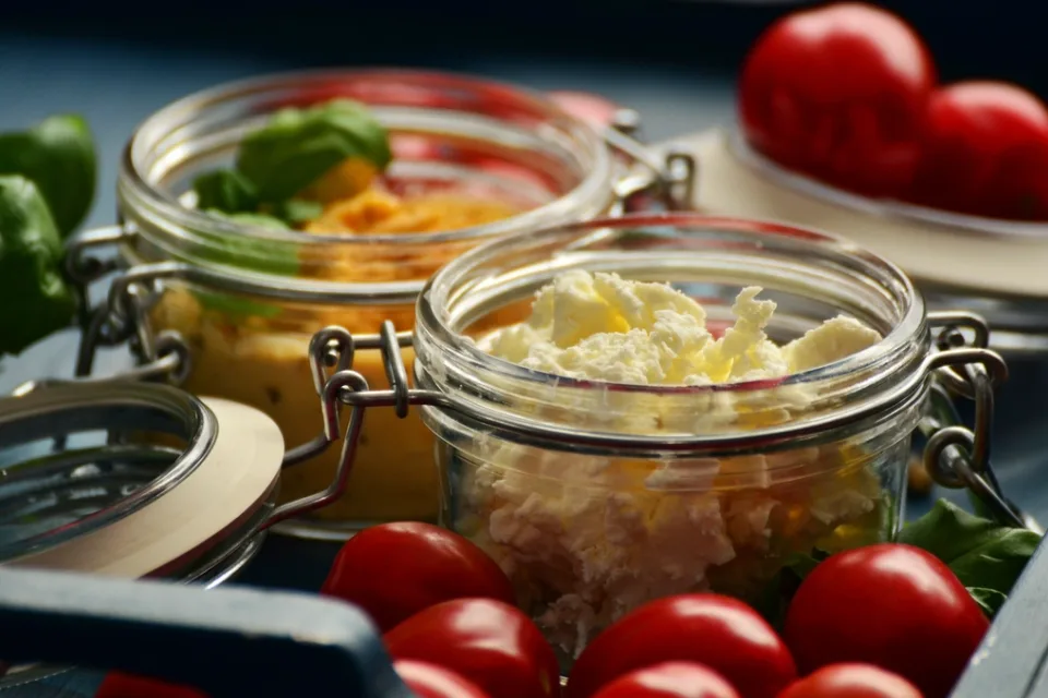 Potes de vidro com salada e tomatinhos numa bandeja